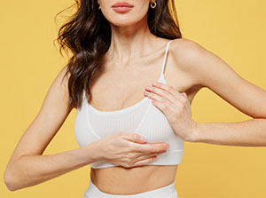 Young caucasian woman in white brassiere underwear put hand on chest
